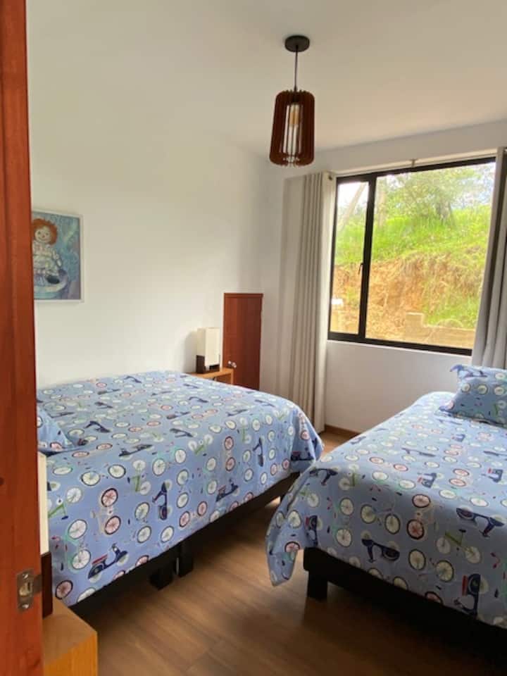 Chumba cha kulala cha ghorofa ya kwanza kilicho na kitanda cha watu wawili na kitanda kimoja, chenye bafu la kujitegemea na televisheni mahiri