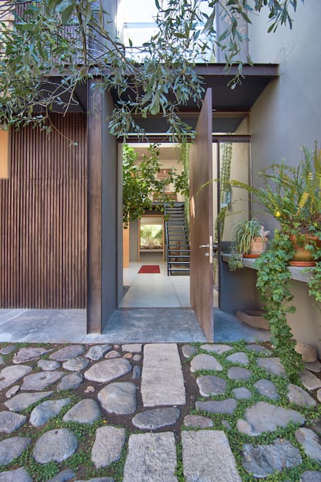 Pivoting metal door opens from carport to entry. Come on in!