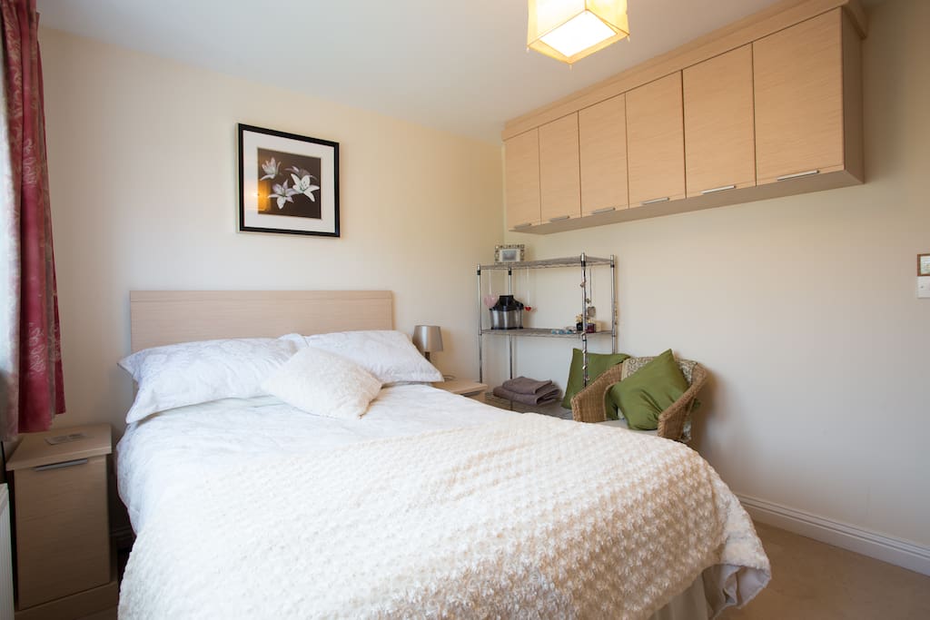 Double bed with fitted cupboards & wicker chair