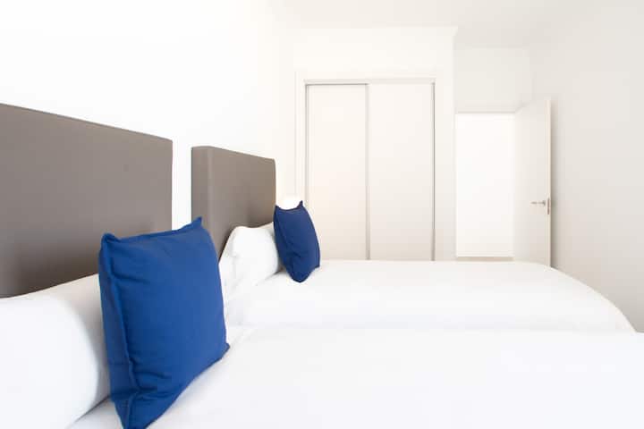 Dormitorio con camas individuales, armario, aire acondicionado.