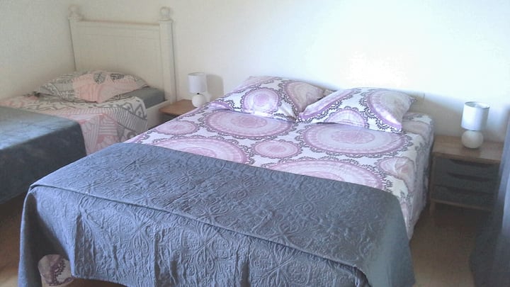 Habitación con cama doble de 140x190, cama individual de 90x190, 2 mesitas de noche, mueble de almacenamiento,  estantes. 