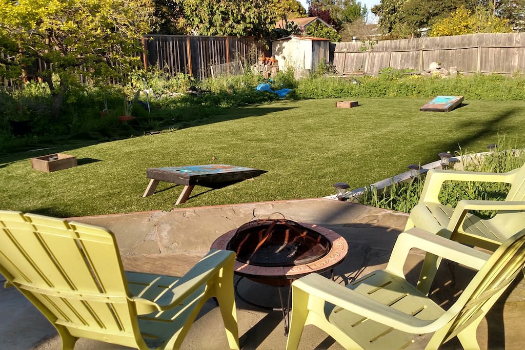 Huge backyard with deck, bbq, firepit, cornhole, washers, and ping pong