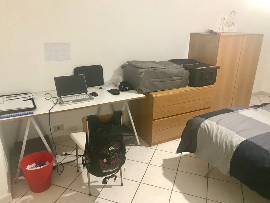 Hay escritorio, armarios, y caneca de basura