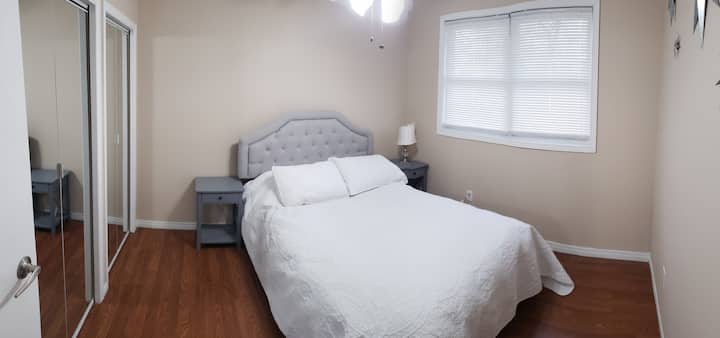 Double bed with nightstand, lamp, chair , ceiling fan and double closet.