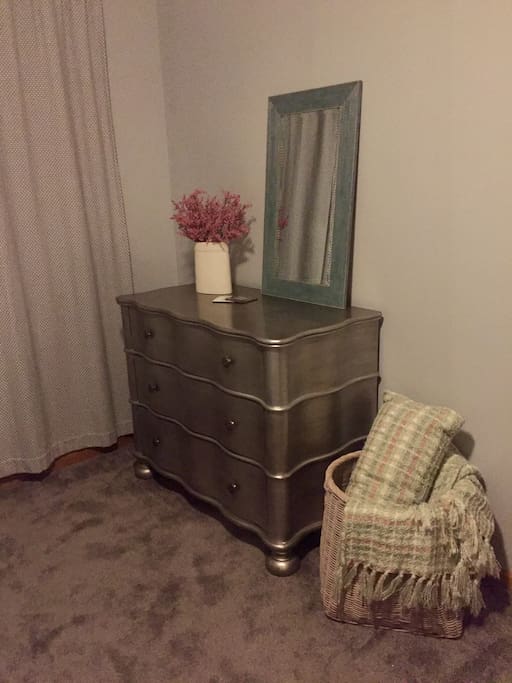 Dresser for guests, mirror, and extra blankets in the bedroom