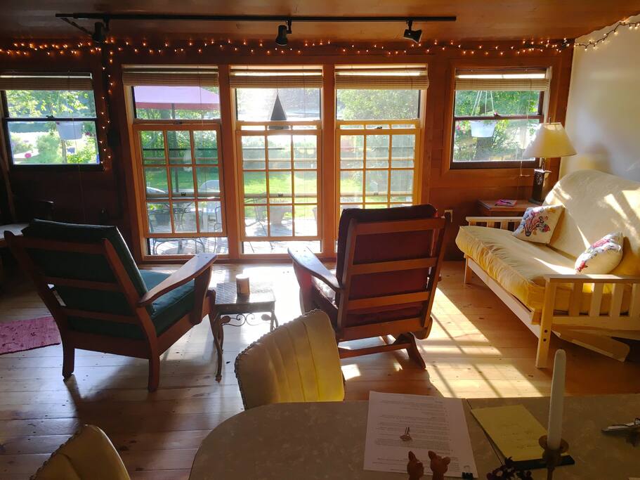 Our cozy Living Room with a great view of the pond and the flowers on the deck! Full size comfy futon for two.