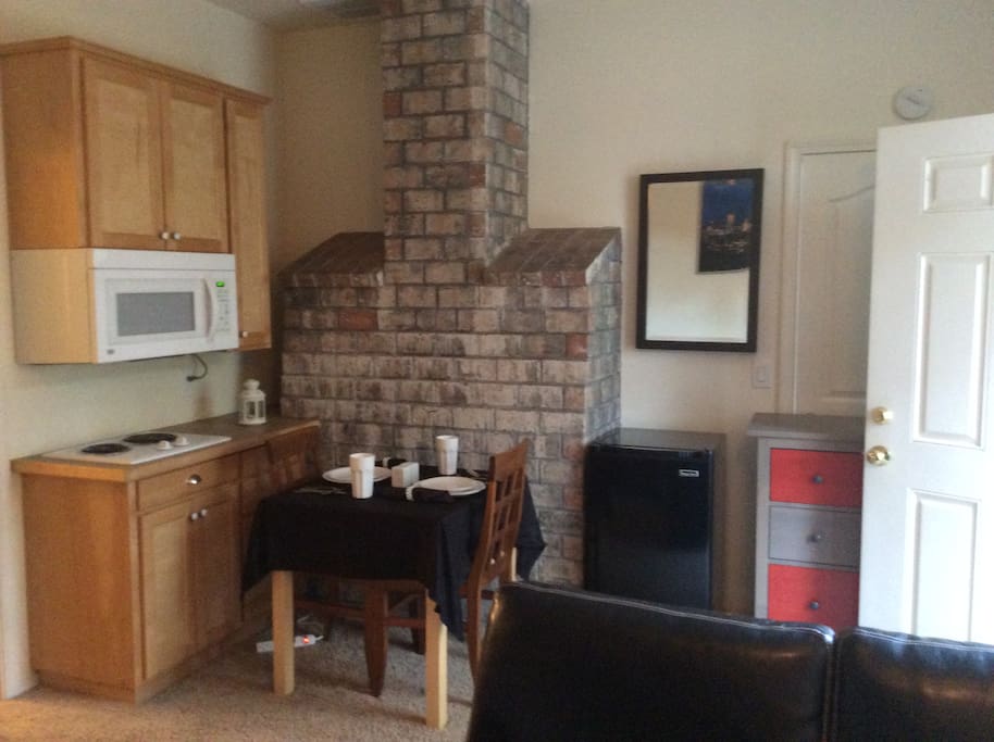 Dining area with Microwave, Refrigerator, table & 2 chairs.