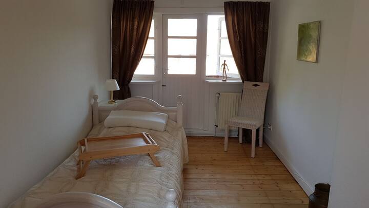 A cozy single bed. The room has access to the balcony.