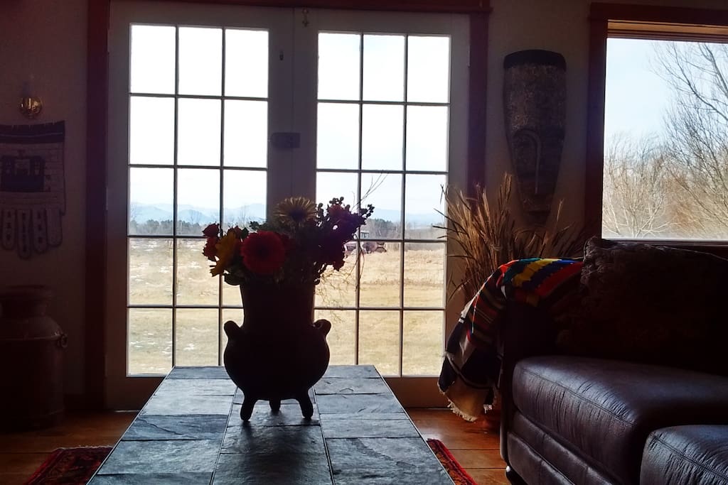 Antique French doors open to the organic meadows and Adirondack mountain views.