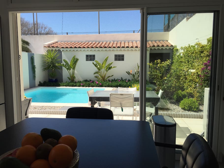 La cuisine donne sur la terrasse et la piscine .