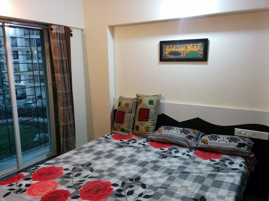 Bedroom with a bed of size 6 feet wide and 7 feet long making it comfortable for even tall people. It also has a work desk, and a wardrobe.