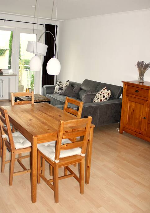 Wohnzimmer mit Essbereich, Couch, Ohrensessel, Kommode und Bücherregal (alle Bücher stehen zum Schmökern zur Verfügung).
Living room combined with dining room, including a couch, a sideboard and a lot of books (for your enjoyment)