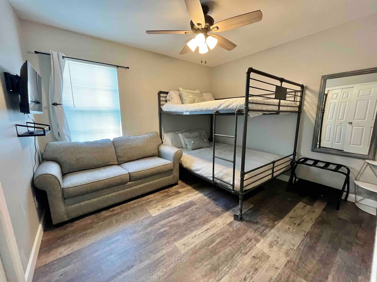 מיטת קומתיים זוגית רחבה מעל קווין סייז עם ספה נפתחת.