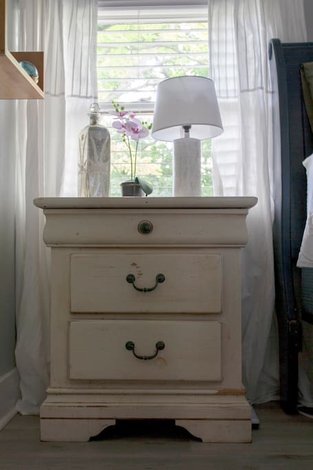 A nice nightstand and reading light is available for you as you snuggle in bed.