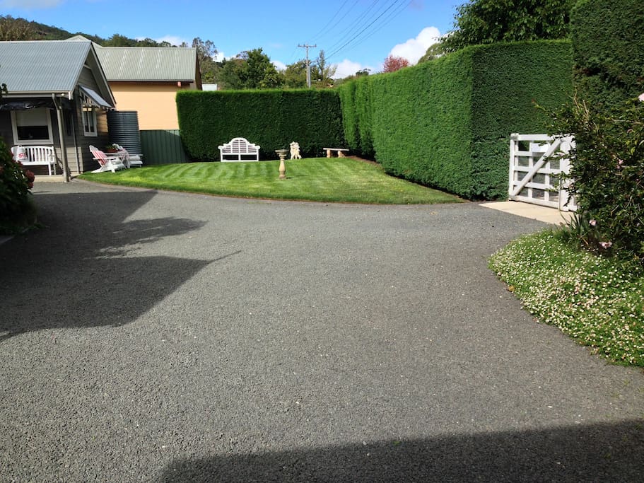 Surrounded by manicured gardens and hedge.