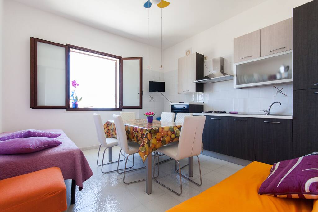 Cucina soggiorno con ventilatore a soffitta, letto singolo, divano letto, tv e vista mare