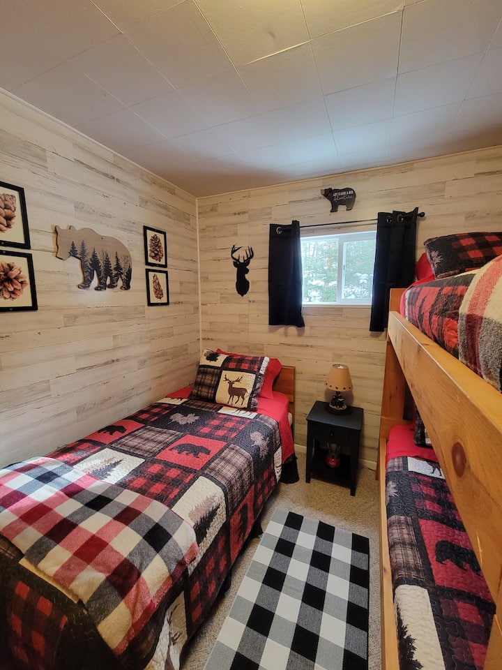 Novouređena spavaća soba s dva odvojena kreveta i jednim krevetom na kat.