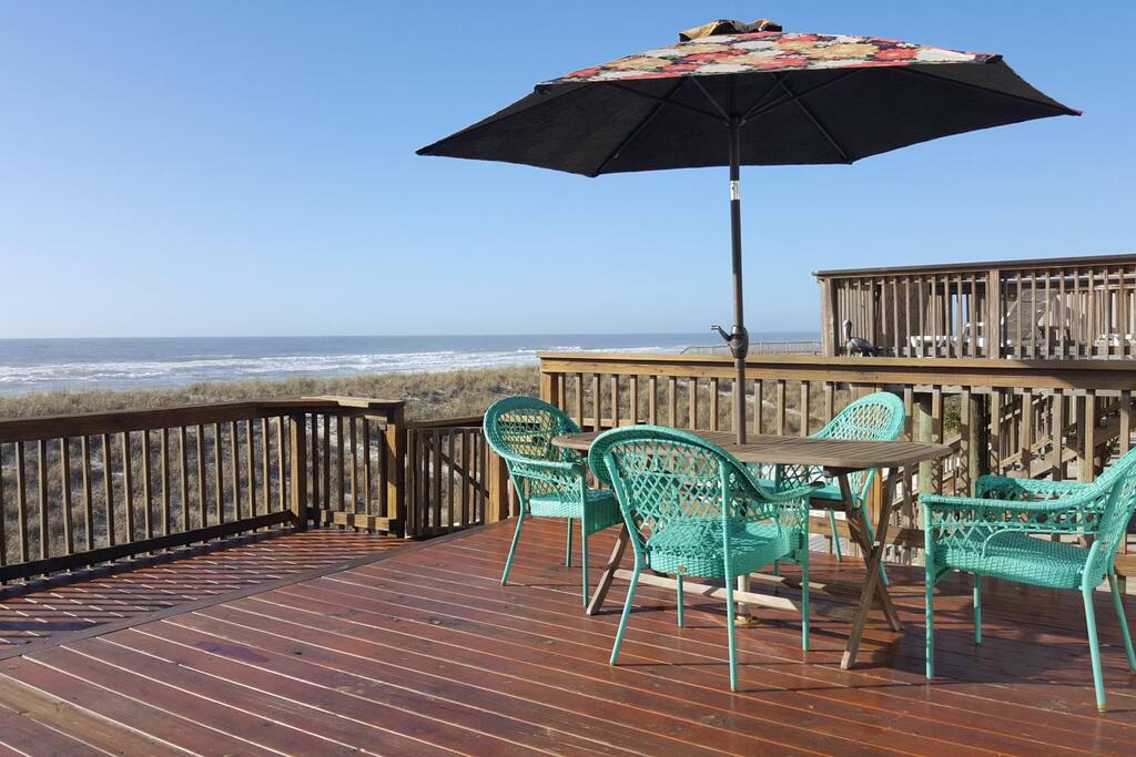 Porch view with table, chairs, and umbrella