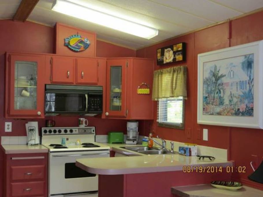 full kitchen with dishes, pots, pans, blender, full refrigerator, stove and utensils!