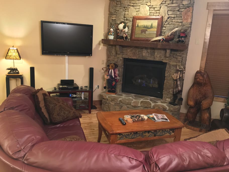 Living room. Large sectional couch, recliner, flat screen TV, and gas fireplace