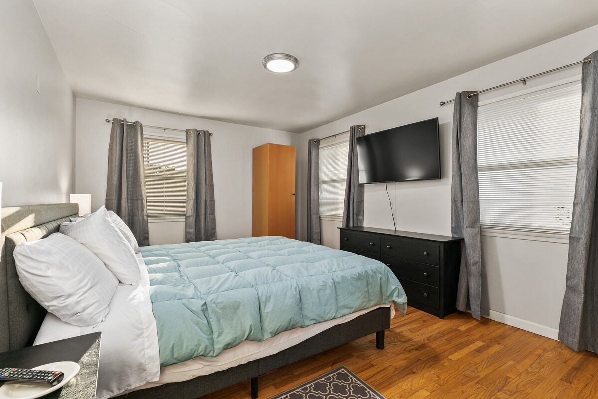 חדר שינה ראשי עם חדר ארונות וטלוויזיה חכמה עם כבלים. וילונות שחורים