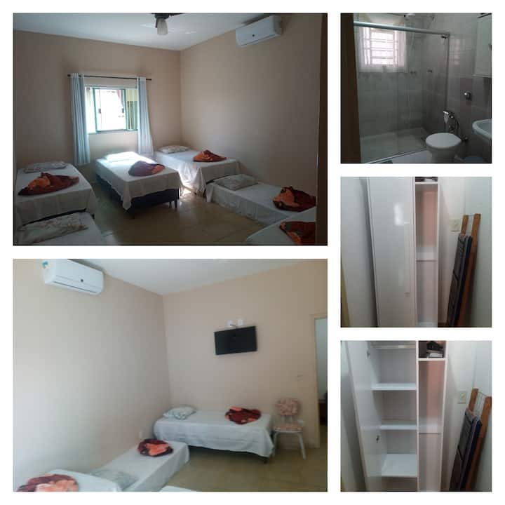 Suite 1 con aire acondicionado, ventilador de techo, televisor inteligente, armario y plancha eléctrica.