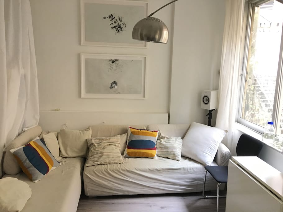 living room, 2 big windows, large sofa, foldable table for dining.