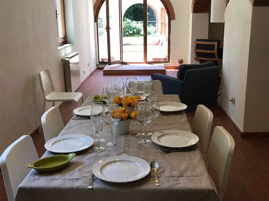 il tavolo da pranzo apparecchiato con bicchieri da prosecco, vino bianco e rosso; in toscana il vino è centrale!