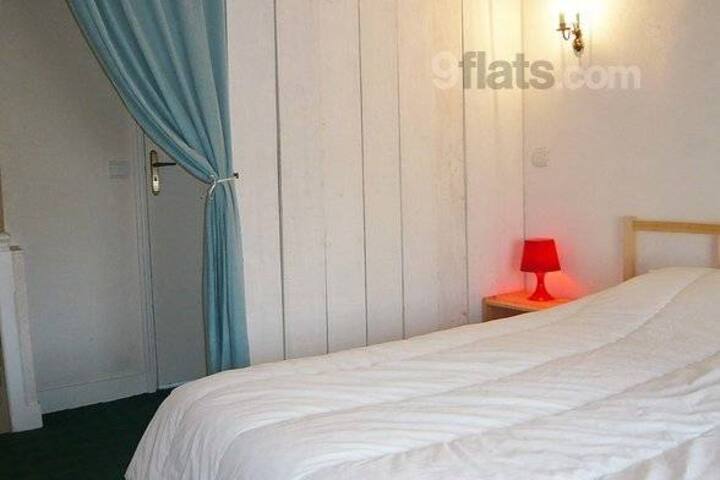 habitación con medio tabique, cama de 140, edredón, manta