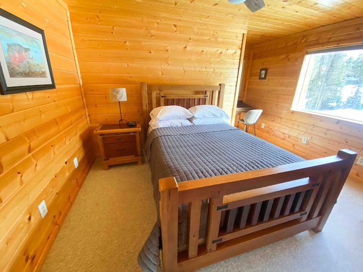 חדר שינה בקומה הראשית עם שולחן כתיבה וסוויטה. 