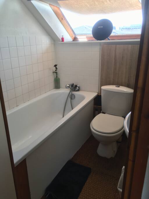 La salle de bain avec grande baignoire et sol en jonc de mer.