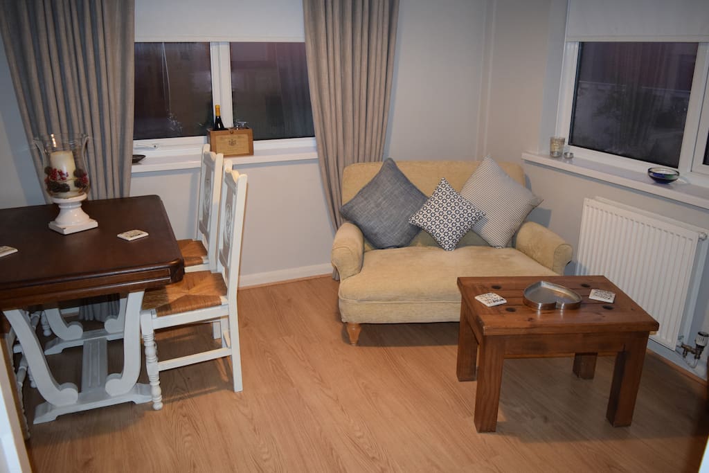 Living room with dinner table for four and digital TV.