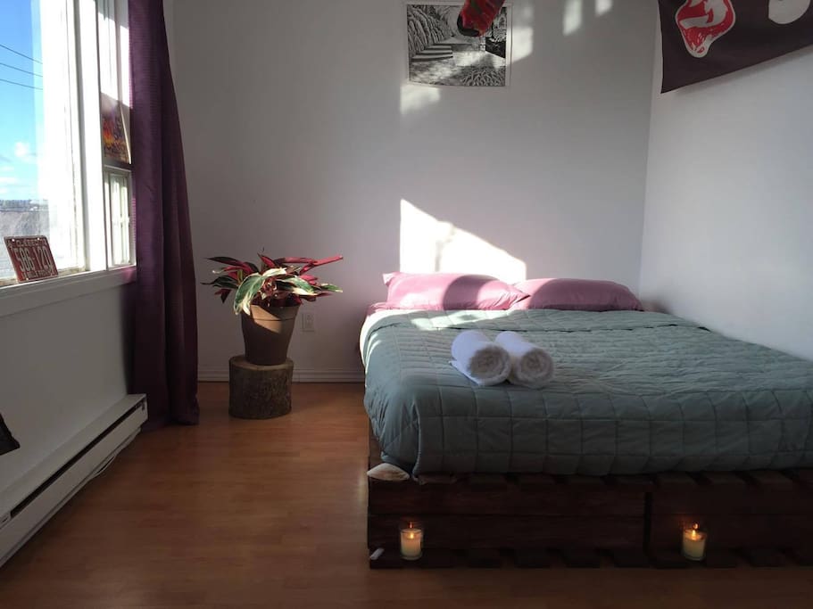 Base de lit en bois de palette. Bain de lumière exceptionnelle et vue sur la ville. Rideau à l'épreuve de la clarté ;)