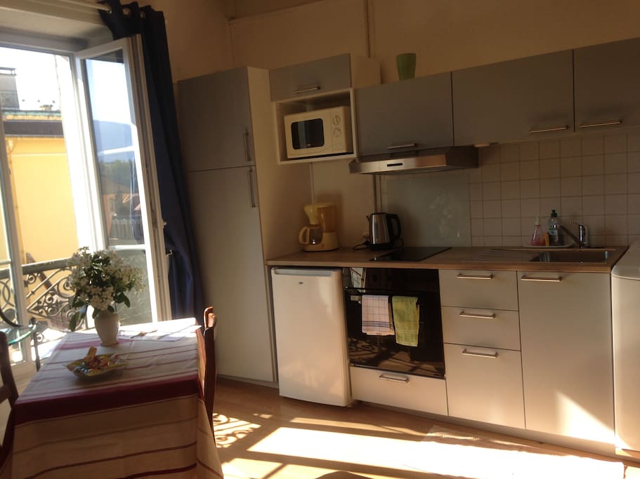 côté cuisine très fonctionnel : lave linge, four, plaques, réfrigérateur, hotte aspirante.
