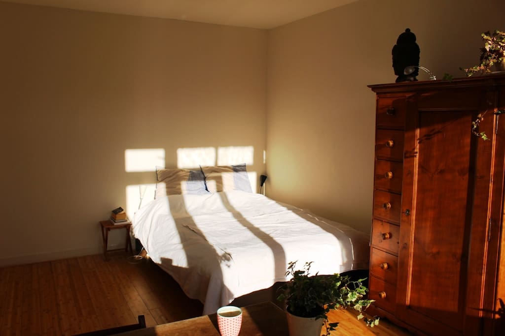 The sunny large bedroom with a comfortable bed