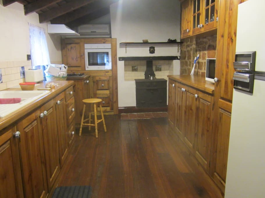 Spacious kitchen with wood stove, gas stove, electric oven & microwave