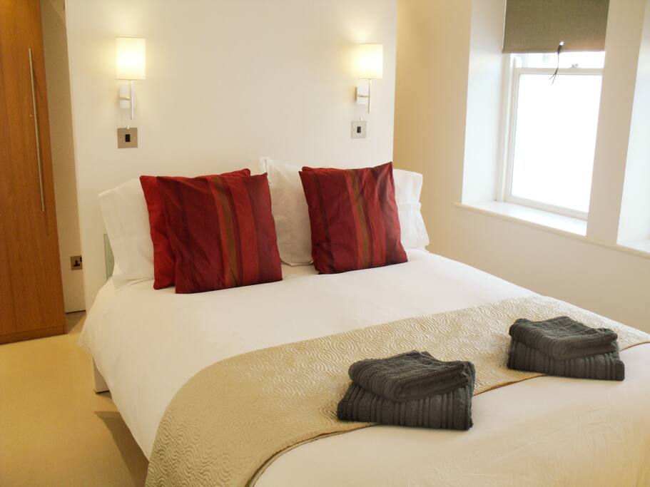 Light bright bedroom with king size bed and walk in wardrobe.