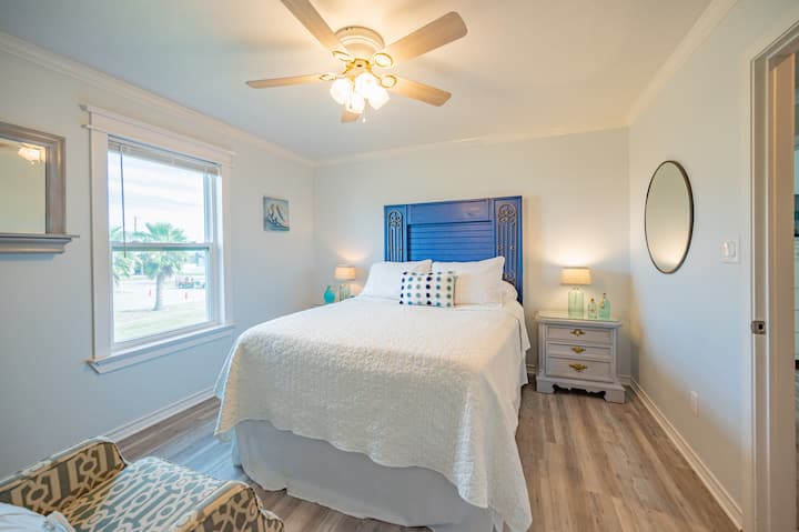 นี่คือห้องนอนด้านหน้าที่มีเตียงควีนไซส์