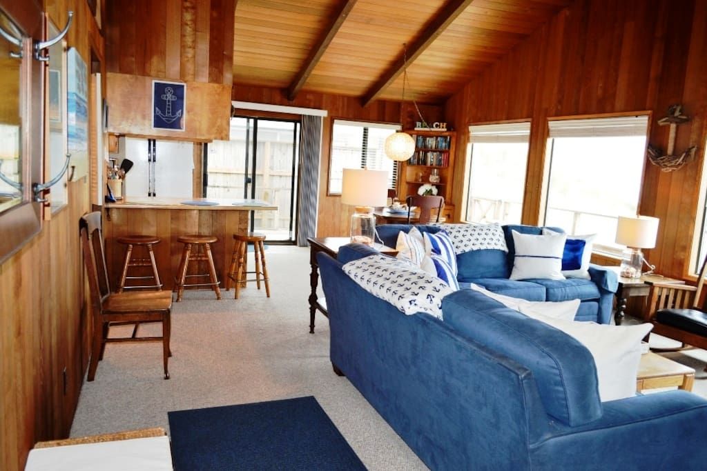 Living room with a flat screen satellite TV/DVD player, wood burning fireplace, two couches and spectacular ocean views