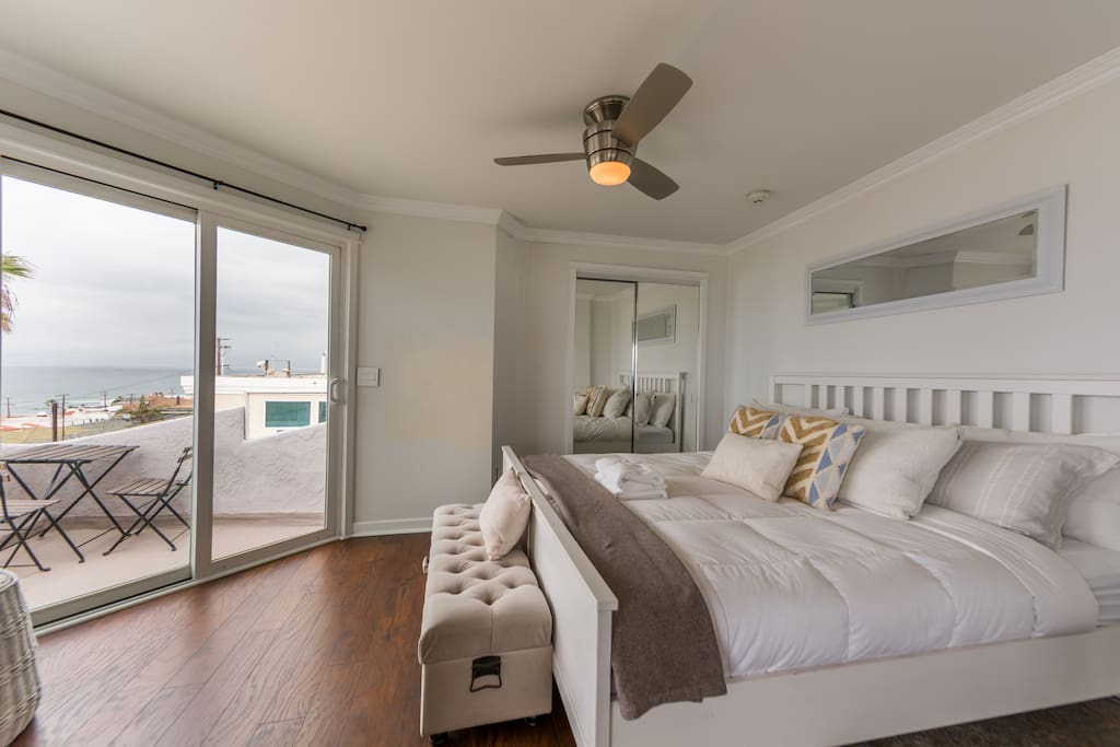 Master bedroom with king-size bed, TV, ceiling fan and direct access to balcony
