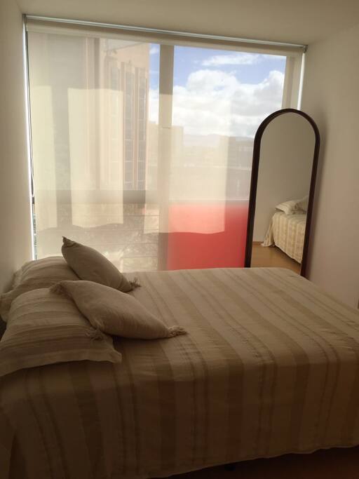 Comfortable bedroom with double bed and a mirror/Cómodo cuarto con cama doble y espejo de cuerpo completo