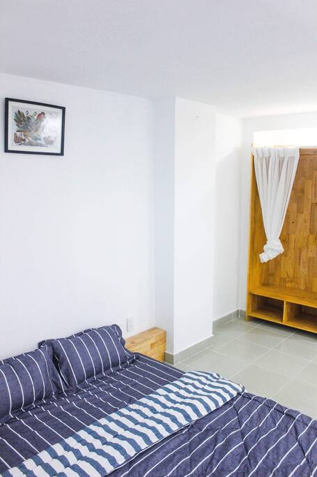 A king-sized bed in a cozy private room with a little bedside table