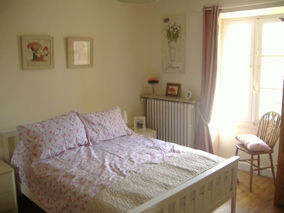 Bright, sunny bedroom with a double bed.