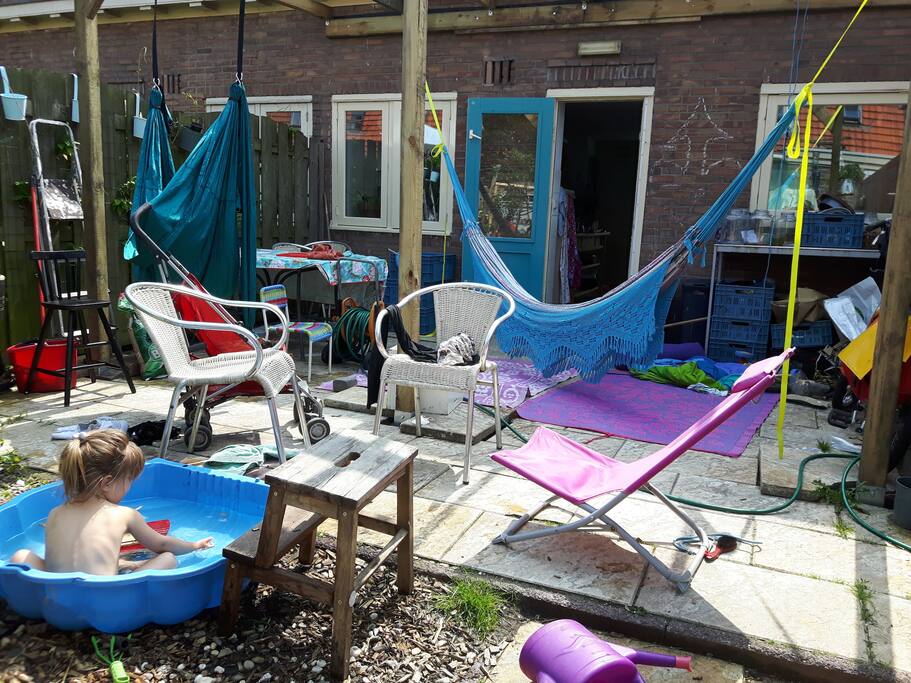 Sunny backyard with hammock, fireplace and enough seats to relax