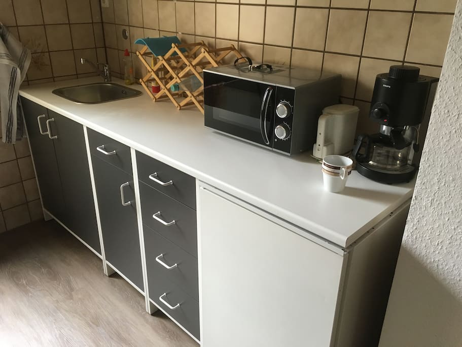 kleine Küchenzeile mit Mikrowelle, Wasserkocher und Kaffeemaschine