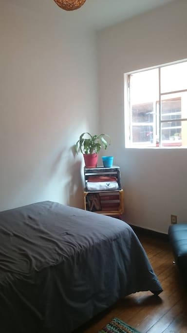 Cama matrimonial y área para colocar ropa