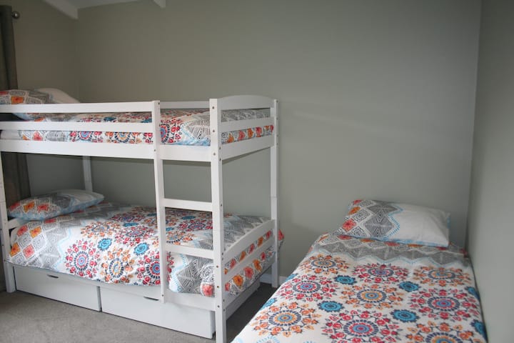 Bedroom 3 with single and bunk beds, dresser and built in wardrobe