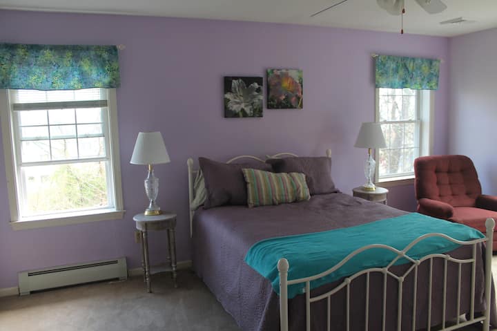 เตียงควีนไซส์และเก้าอี้ในห้องนอนใหญ่