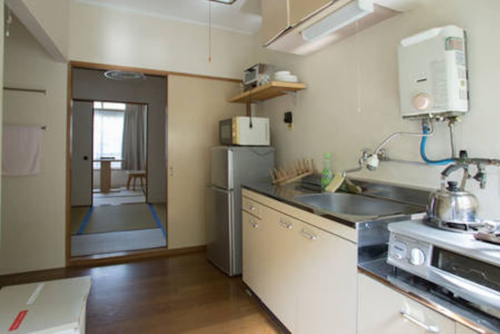 kitchen has refrigerator, toaster, microwave and grill