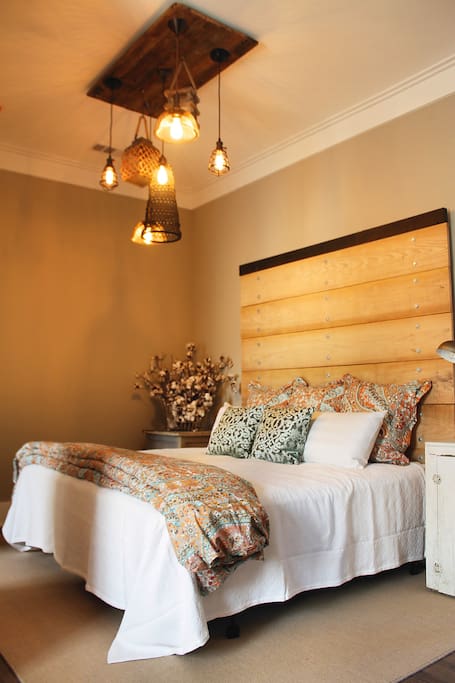 King size bed with fine linens and an industrial headboard made of wood from our farm.